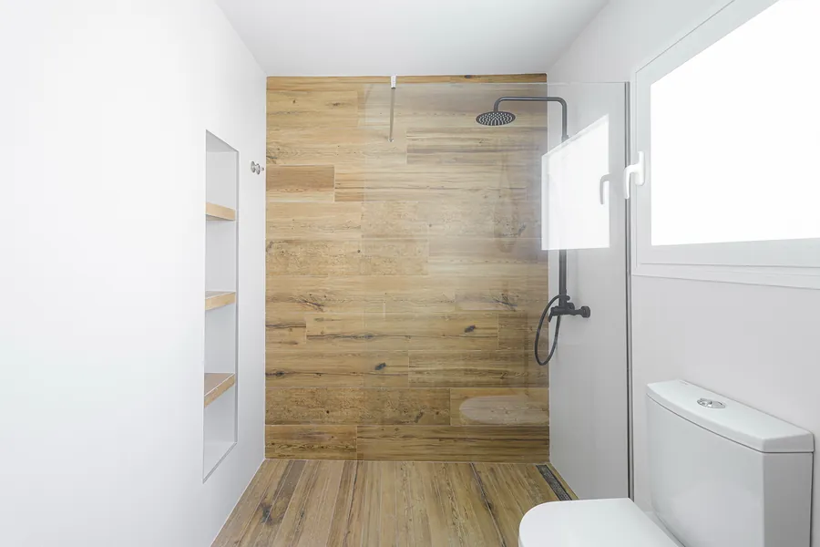 Segundo baño, con el mismo lenguaje de madera y blanco
