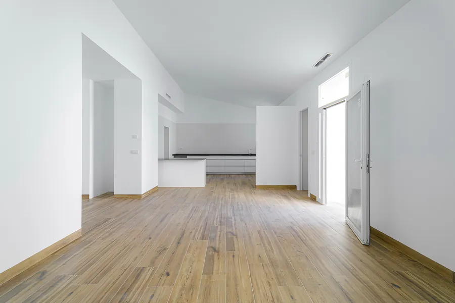 El gran espacio central de la vivienda, con el pavimento de madera y los techos altos