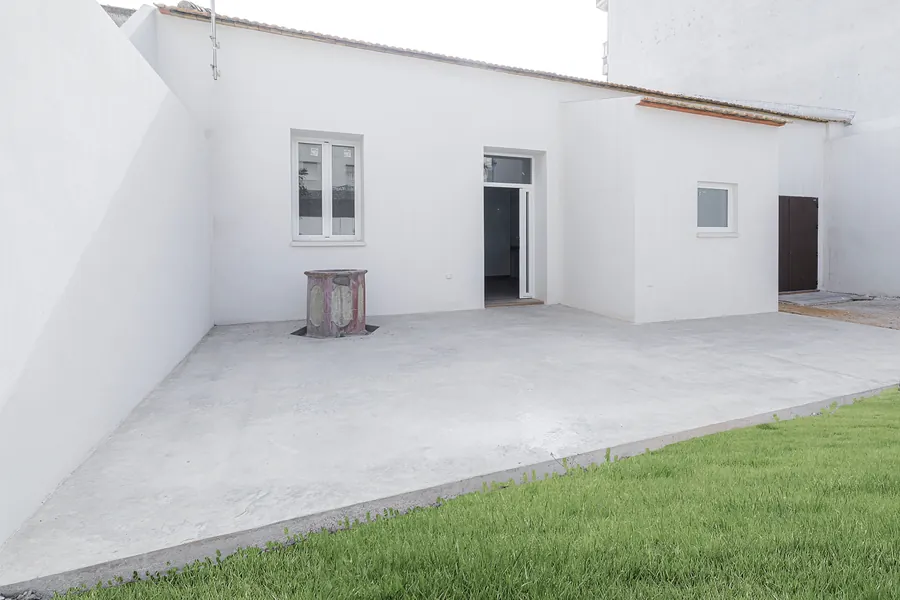 El patio desde el otro extremo, con el césped y el acceso a la casa